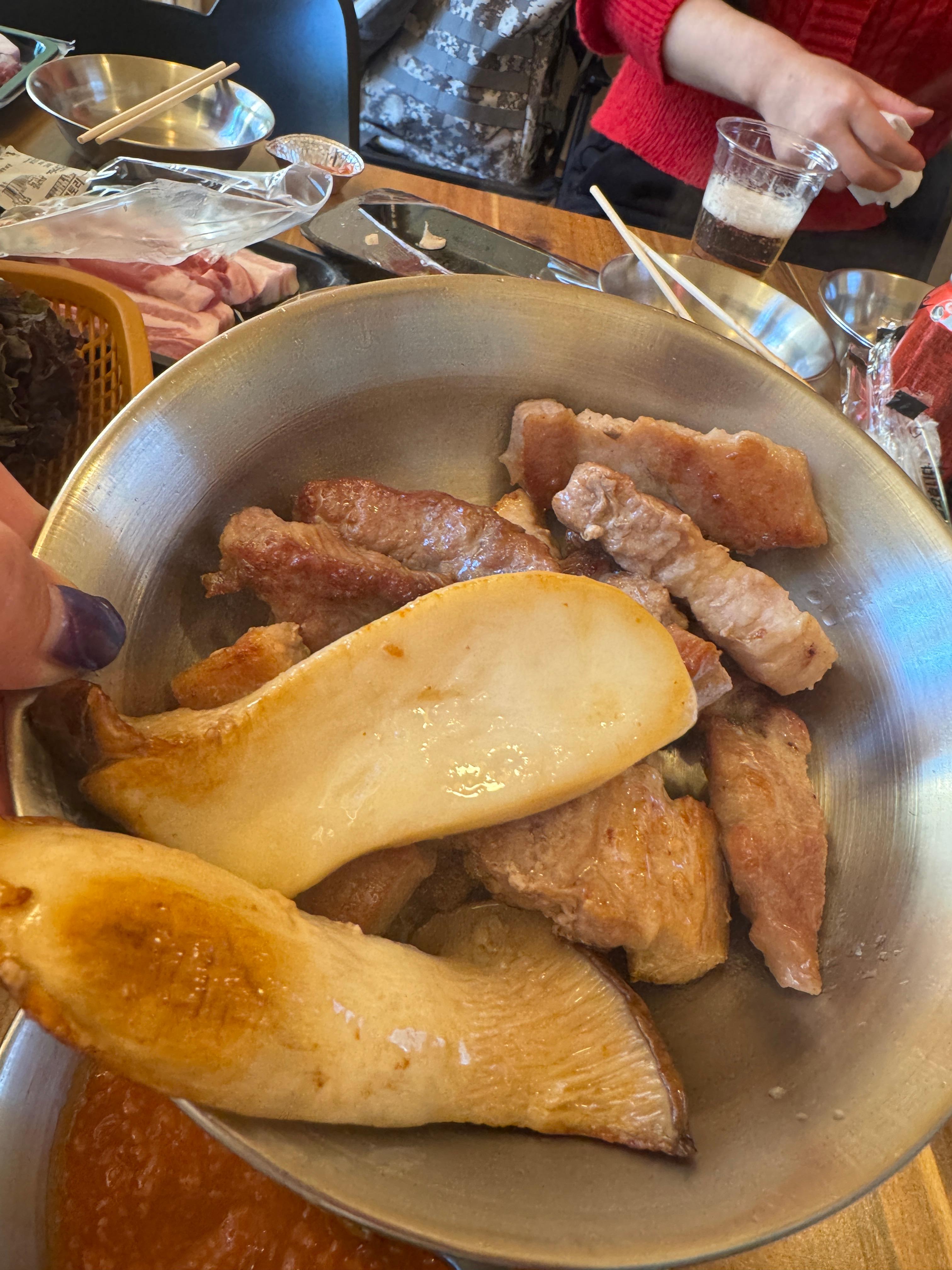 바베큐팩토리 감북점 텐트 내부 불판 위에서 한돈 목살과 큼직한 버섯을 함께 굽는 모습&amp;#44; 숯불 전 버너 조리 