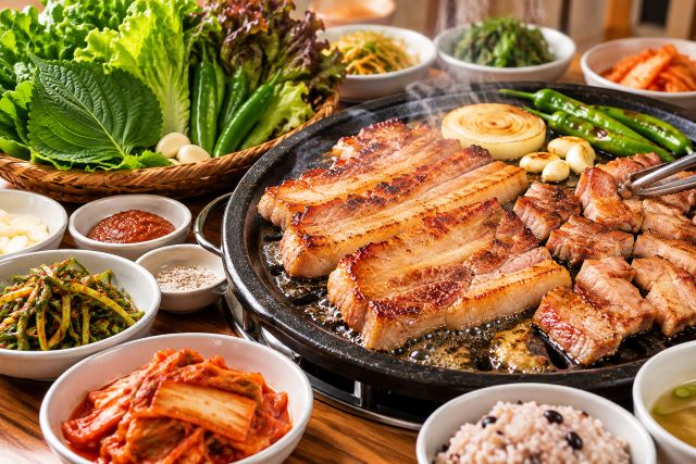 상추와 깻잎, 고추를 곁들인 삼겹살 식탁