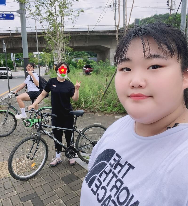 야외에서있는-머리묶은여성의모습-자전거를탄-여성의모습