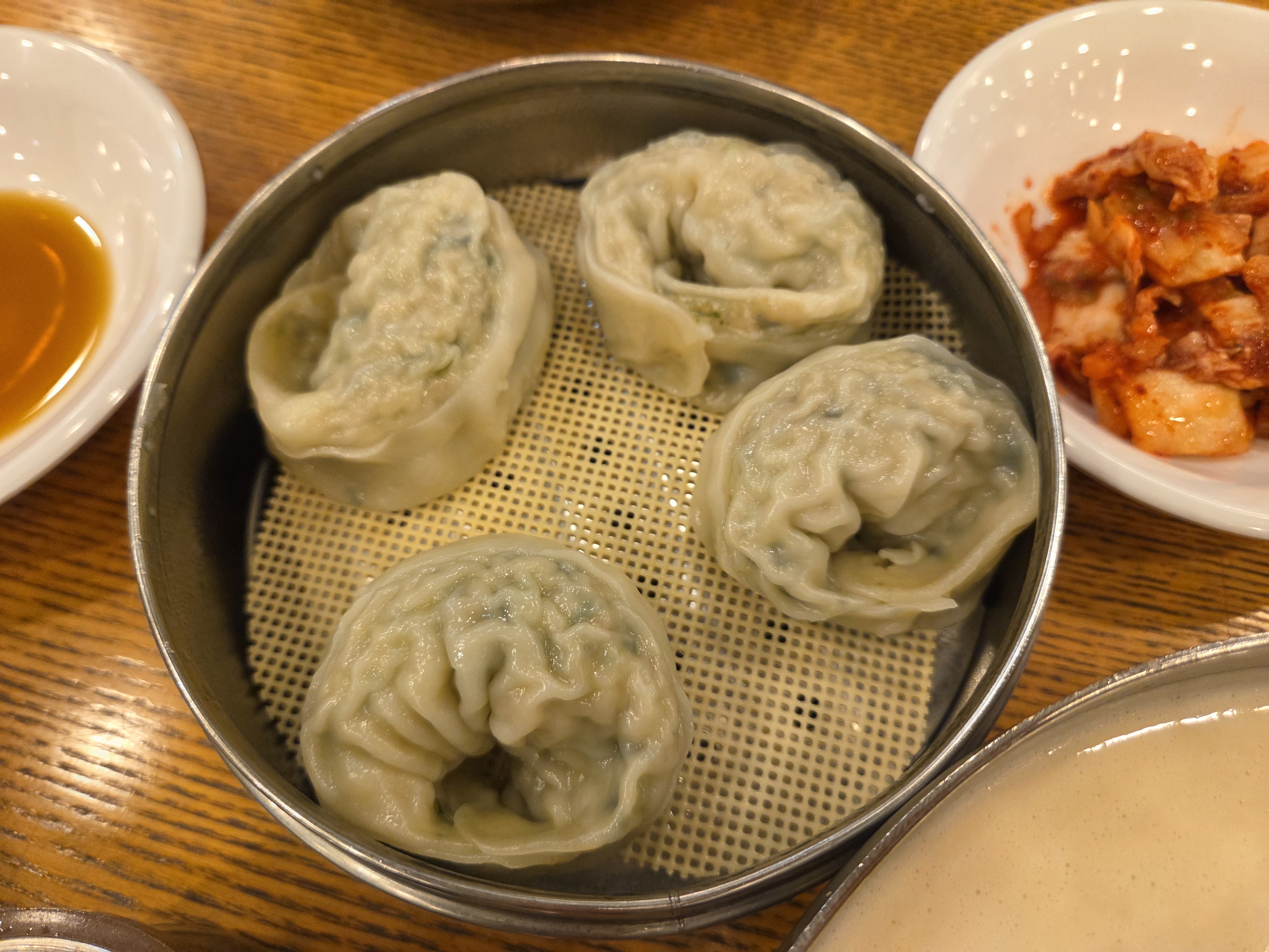 찜기에 담겨 나온 큼직한 손만두 네 개