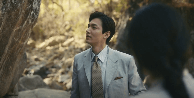 숲속에서 회색정장을 입은 한수의 모습