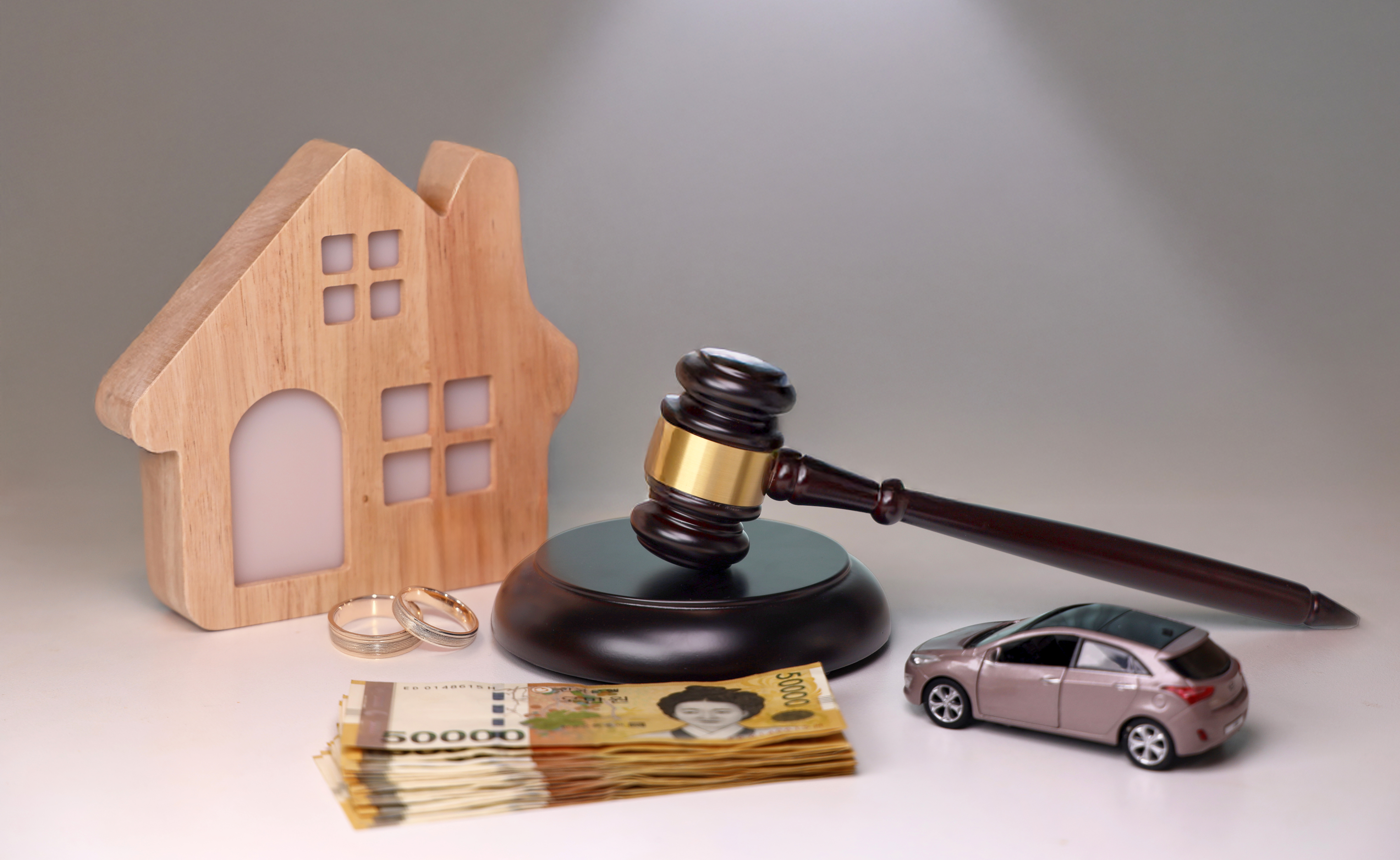 상간자소송에서 위자료와 재산 분쟁을 상징하는 집, 현금, 반지, 자동차 이미지