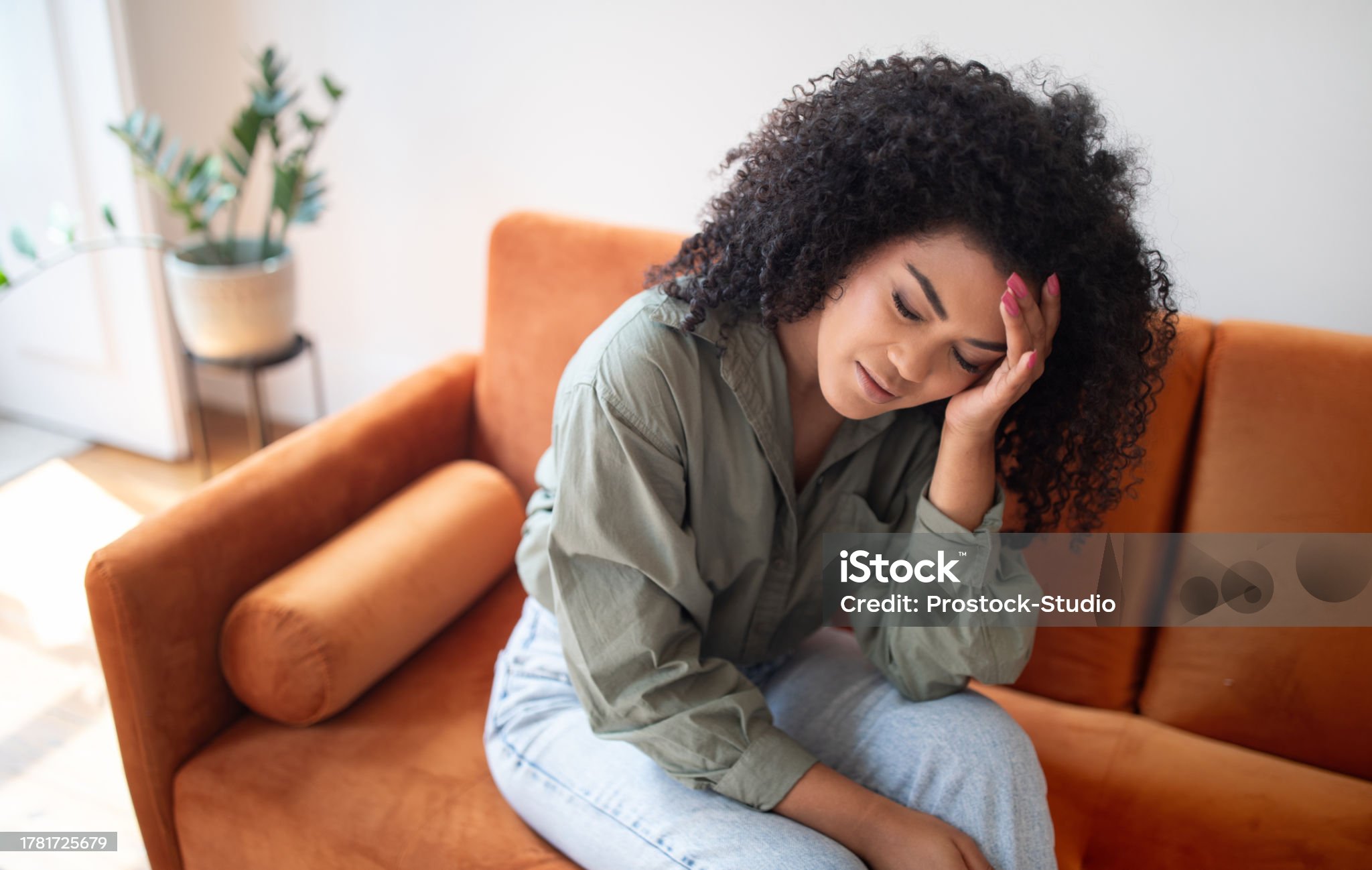 실내 소파에서 두통으로 고통받는 화난 흑인 아가씨
