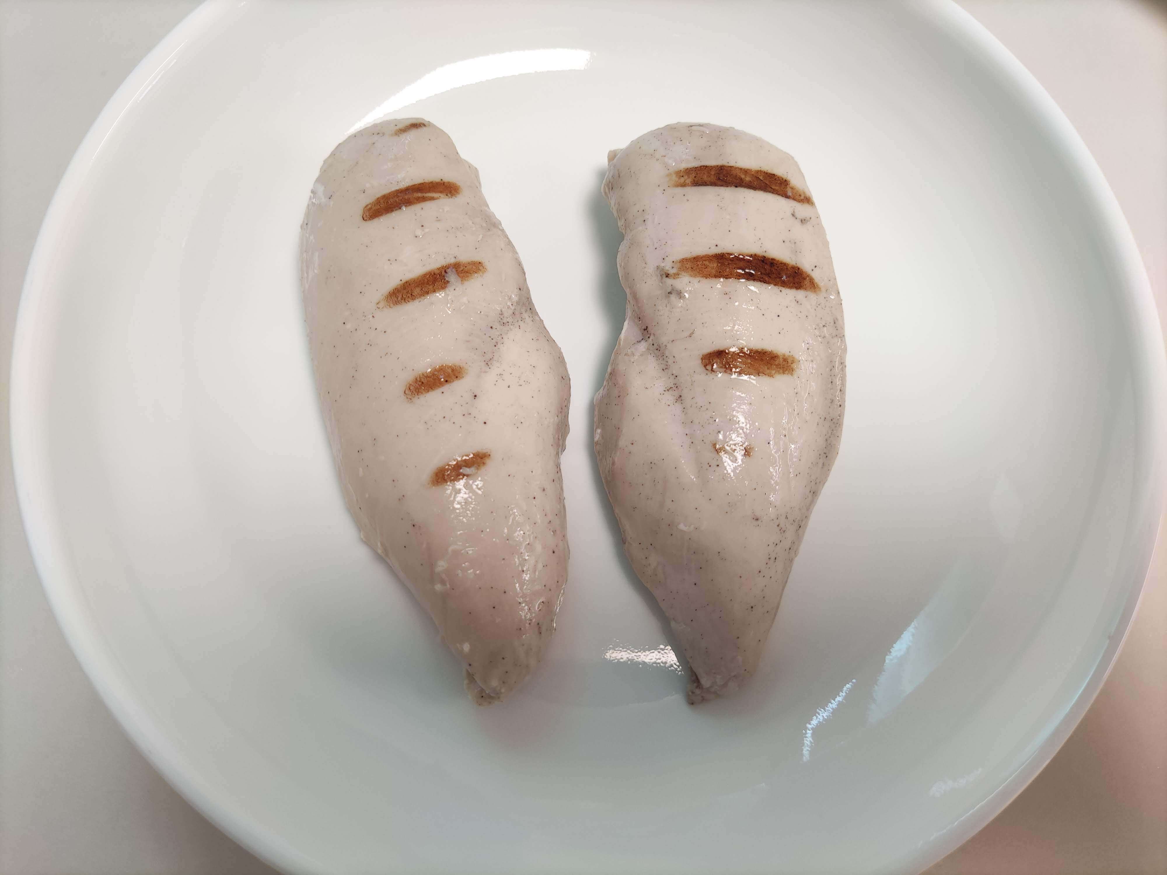 흰 접시에 담긴 그릴드 닭가슴살 두 팩