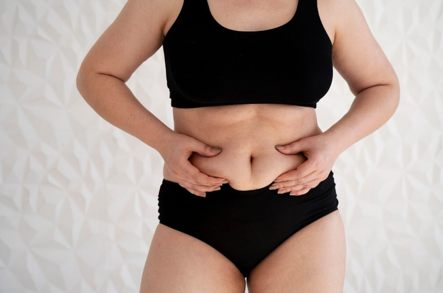 뱃살을 만지고 있는 여성