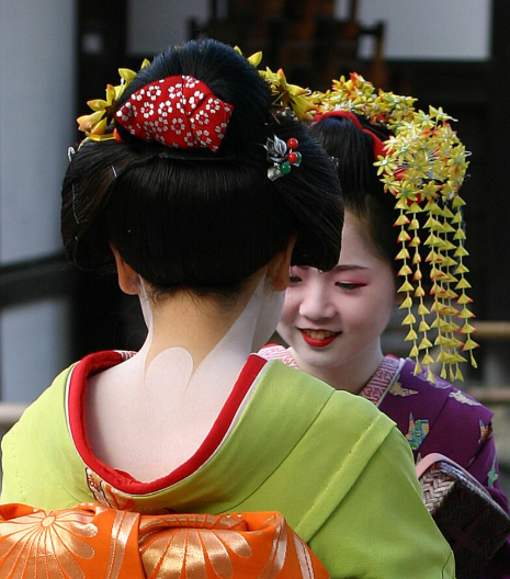 어린 게이샤 두명이 마주보고 있는 사진