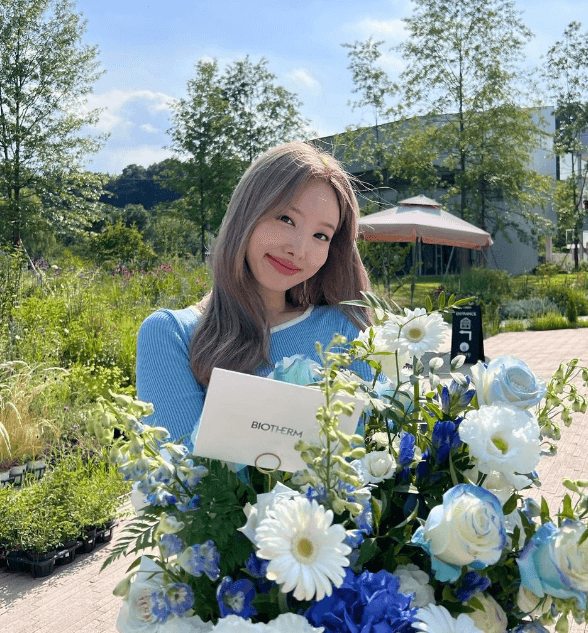 파란 꽃과 함께 있는 나연