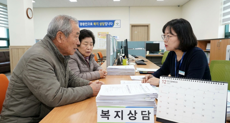 복잡한 서류를 앞에 두고 주민센터 직원과 상담하는 부부