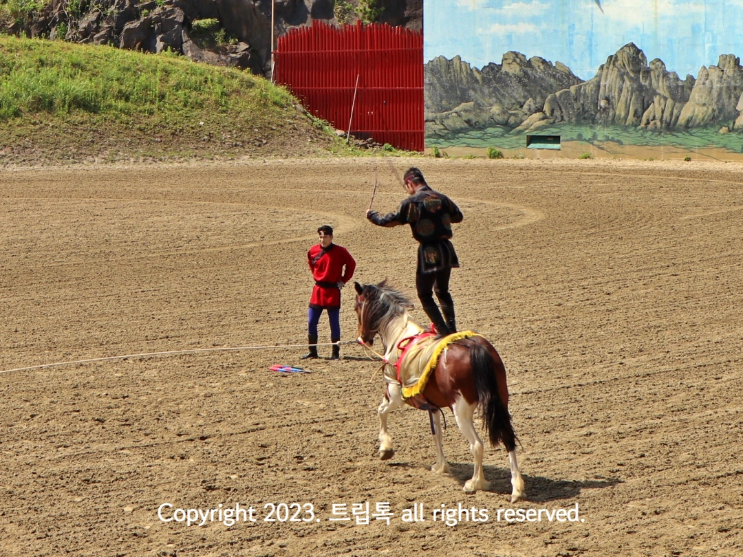 달리는 말위에서 줄넘기 줄을 돌린다.