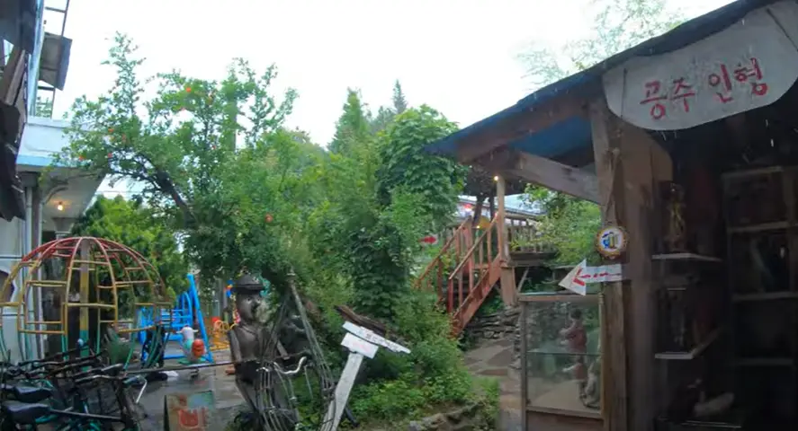 겨울방학 국내 여행지-
숲속 나무들이 울창한 사이 나무로 된 집 윗쪽 흰색배경 빨간글씨 공주인형