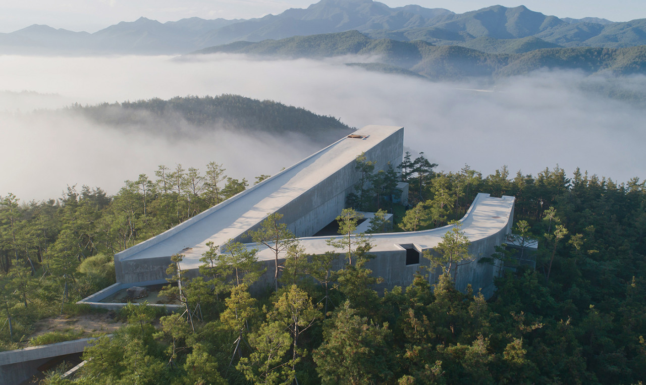 거대한 노출 콘크리트 벽면 사이로 푸른 하늘이 조각처럼 담겨 있으며 고요한 정적이 느껴지는 사유원 소요헌의 전경