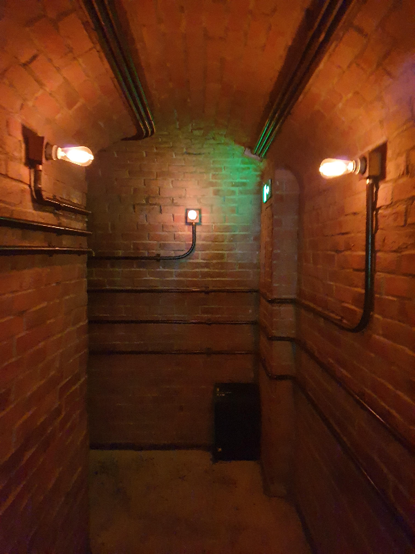 어두운 조명과 붉은 벽돌로 이뤄진 비밀 통로