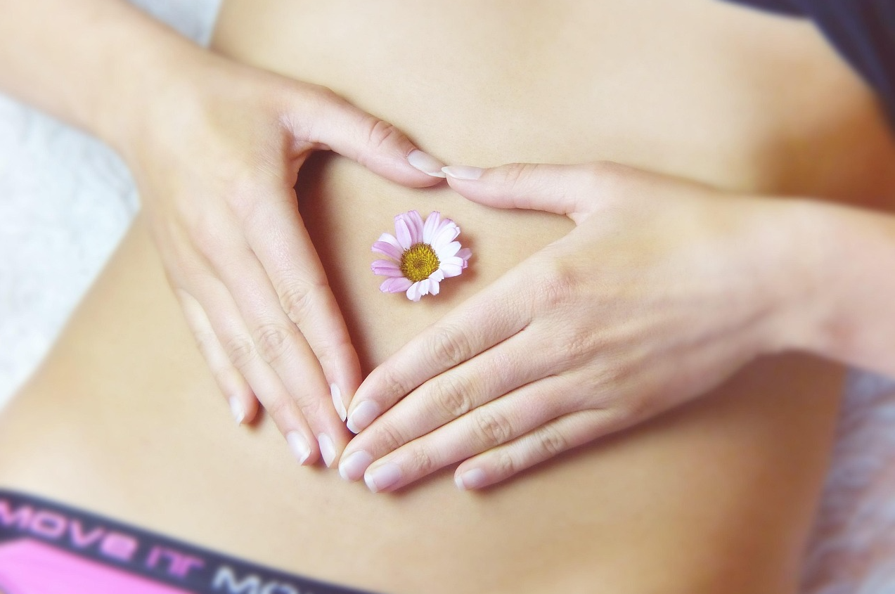 여성이 배 위에 손을 얹고 있다