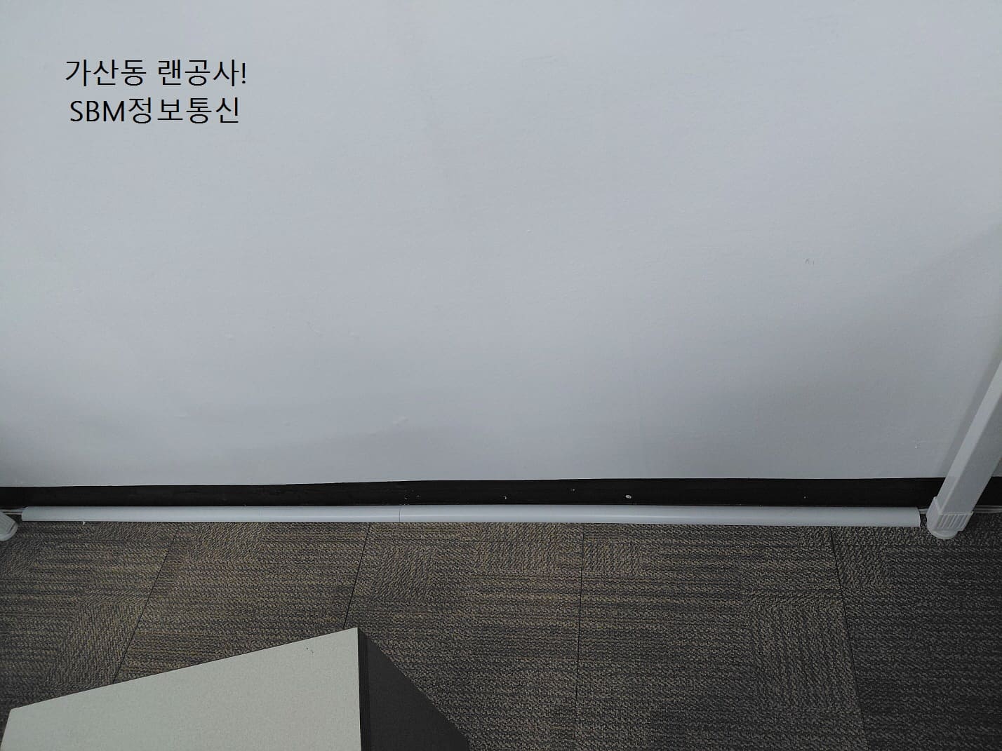 바닥 타일 색상과 조화되는 화이트 톤의 몰딩을 사용하여 일직선으로 곧게 뻗은 깔끔한 배선 처리 모습