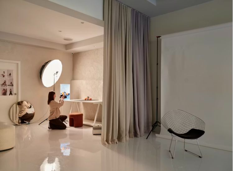 커튼으로 공간을 나누고 최소한의 가구로 정리된 홈 스튜디오