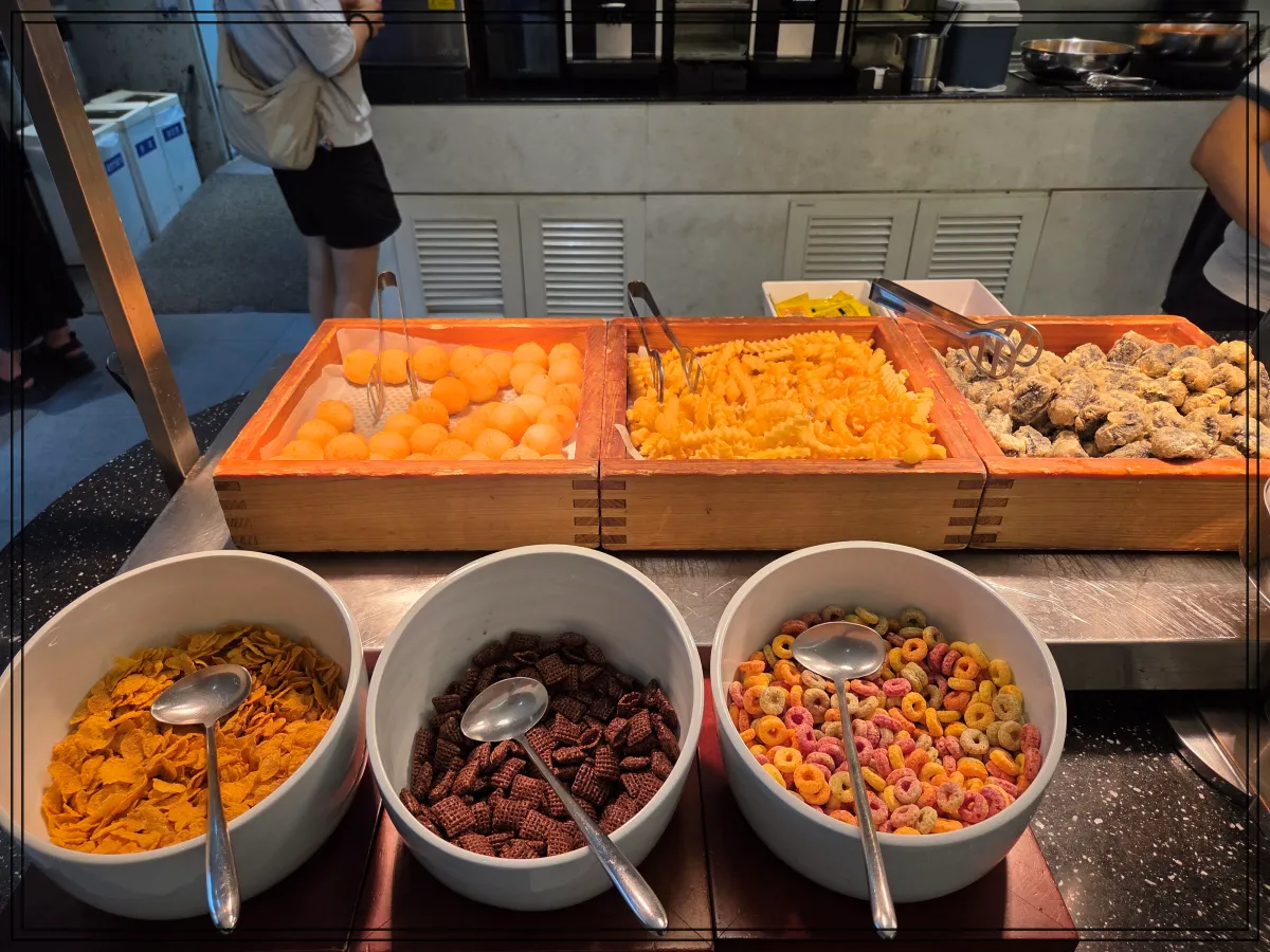 위쪽에는-치즈볼-감자튀김-떡강정이-있고-아래쪽에는-옥수수·초코·후르츠-시리얼이-그릇에-담겨-있음