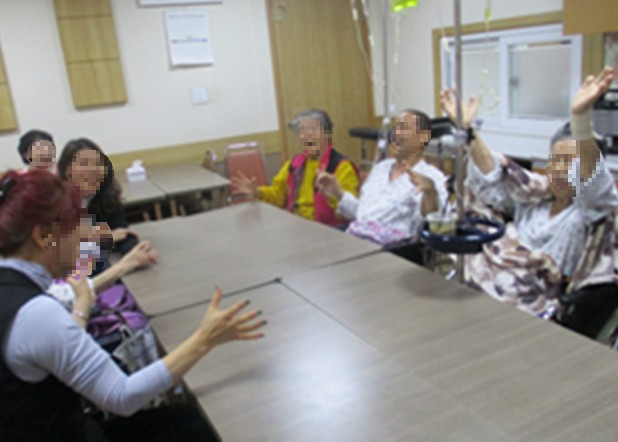 alt=여러 환우와 활동가들이 함께 웃음치료 프로그램에 참여하며 활짝 웃고 있는 모습