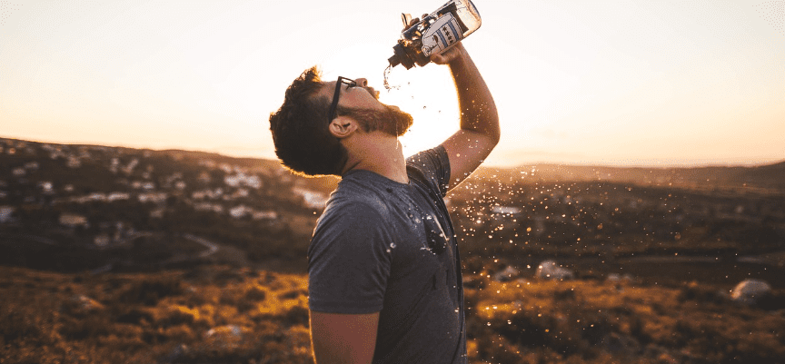 입을 크게 벌리고 생수를 마시고 있는 남자