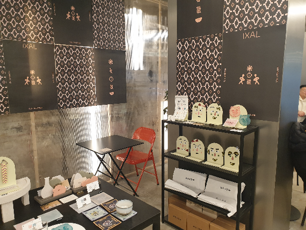 테이블과 기둥 스탠딩 선반에 굿즈들이 놓여있다.