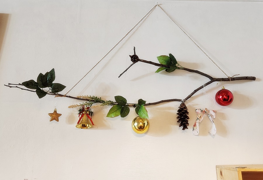 나뭇가지에 조화와 오너먼트 솔방울을 걸어줌