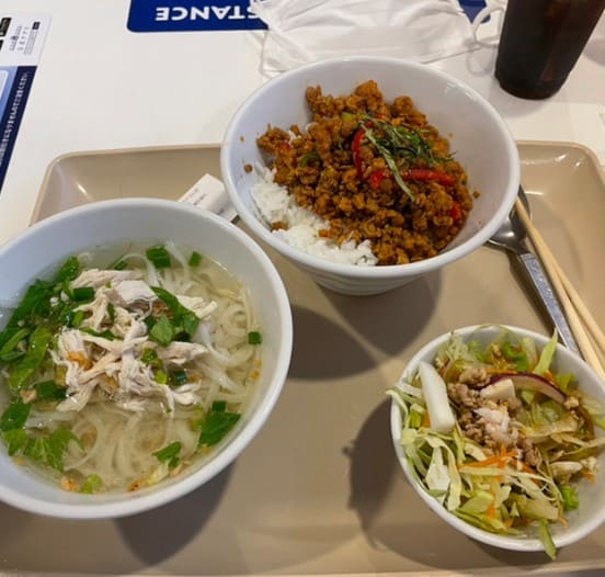 테이블위에 닭고기가 올라간 스프 밥위에 갈색 토핑이 올라가 있는 접시 그리고 야채가 들어간 그릇이 있다.