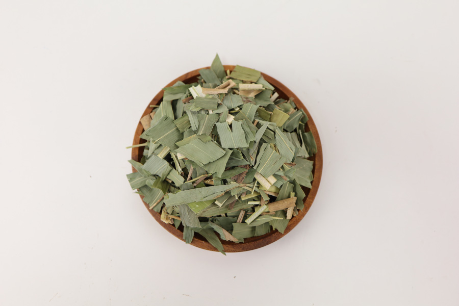 야생에서 채취를 한 담죽엽 나무의 잎을 깨끗하게 세척을 한 후에 편으로 자른 것을 하얀 바닥 위에 고동색의 동그란 나무 그릇에 수북하게 쌓아두고 찍은 사진