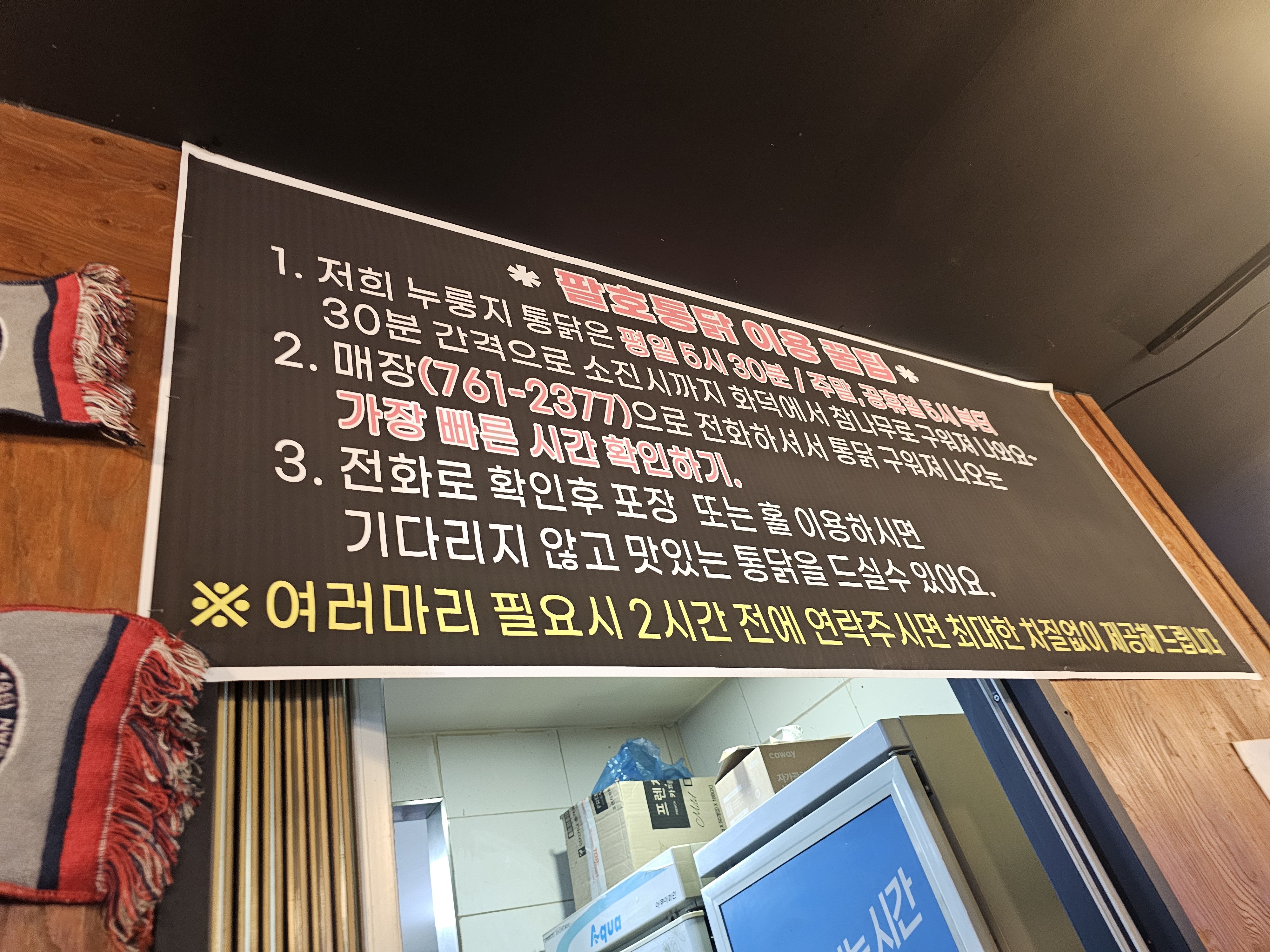 진주 팔호통닭 호탄점 실내 분위기 — 나무 테이블·검은 벽돌 인테리어