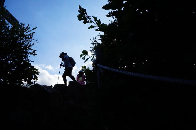 관모봉 정상, 역광 실루엣, 가운데 오른손에 스틱 든 남성 1실루엣,