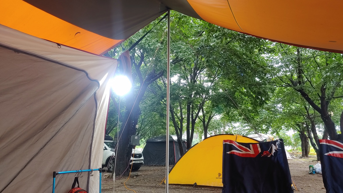 타프와 텐트 그리고 의자가 보이는 캠핑장 풍경