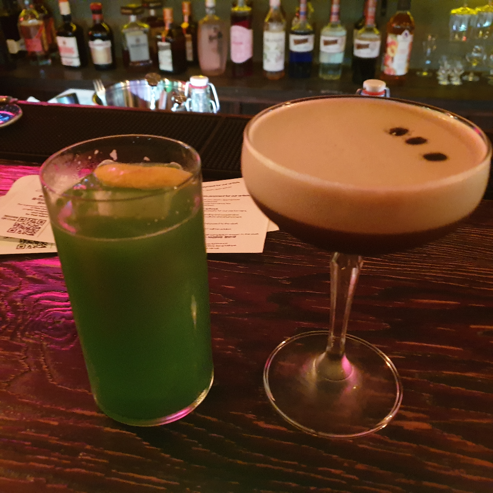 초록색의 칵테일과 원두 3알이 올려져 있는 칵테일