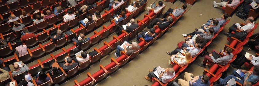 많은 사람들이 강의실에 모여 강의를 듣고 있는 모습의 사진