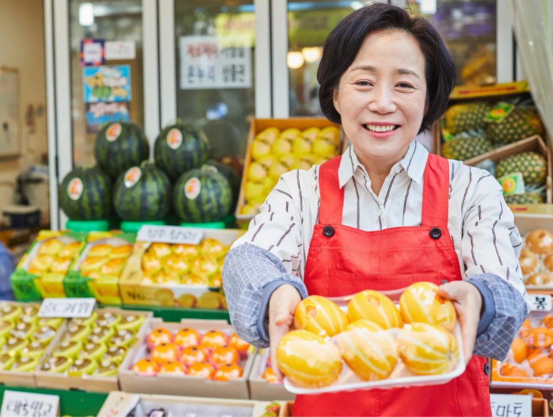 시장 상인이 참외를 들고 있는 모습의 제철 이미지