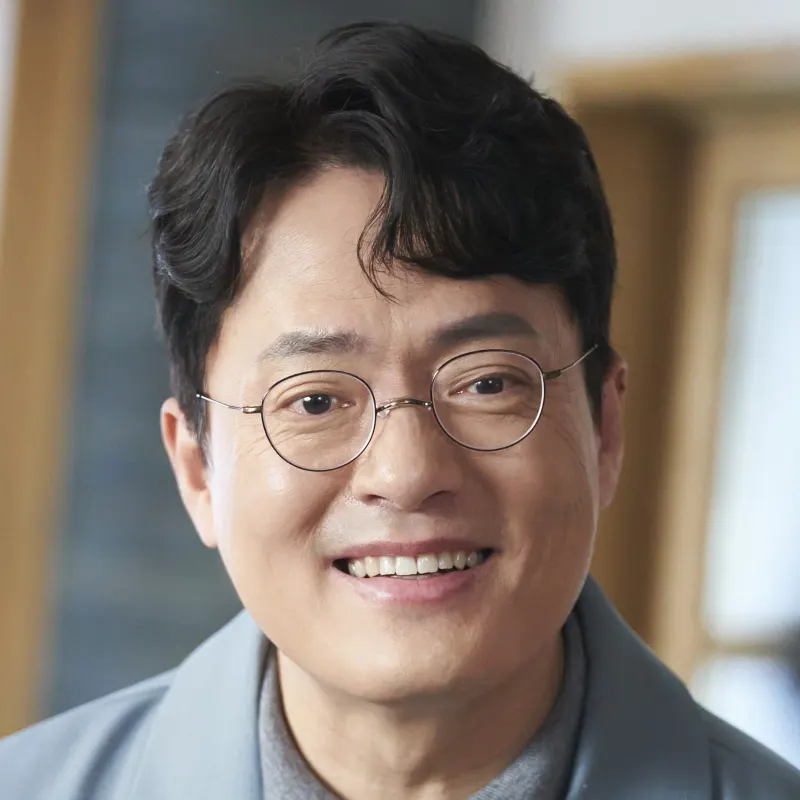 어느 실내를 배경으로 안경을 쓰고 웃고 있는 오랫동안 당신을 기다렸습니다의 추영춘이자 닥터 추