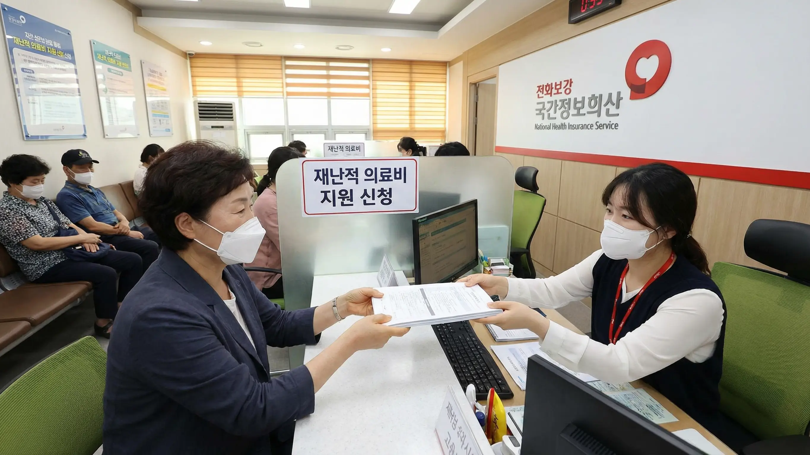 국민건강보험공단 지사 창구에서 상담원에게 서류를 제출하며 재난적 의료비 지원을 신청하는 모습