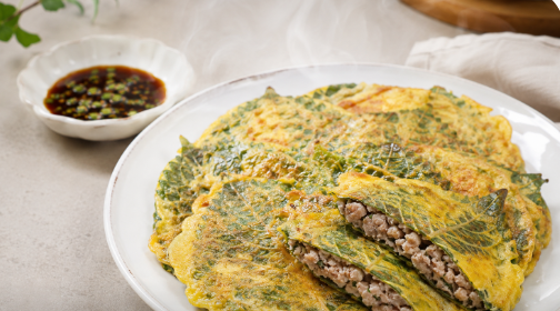 노란 계란 옷 속으로 푸른 깻잎 결이 살아있는 깻잎전들이 가지런히 포개어져 담기고, 속에서 윤기 나는 육즙과 모락모락 김이 피어오르는 전체 완성