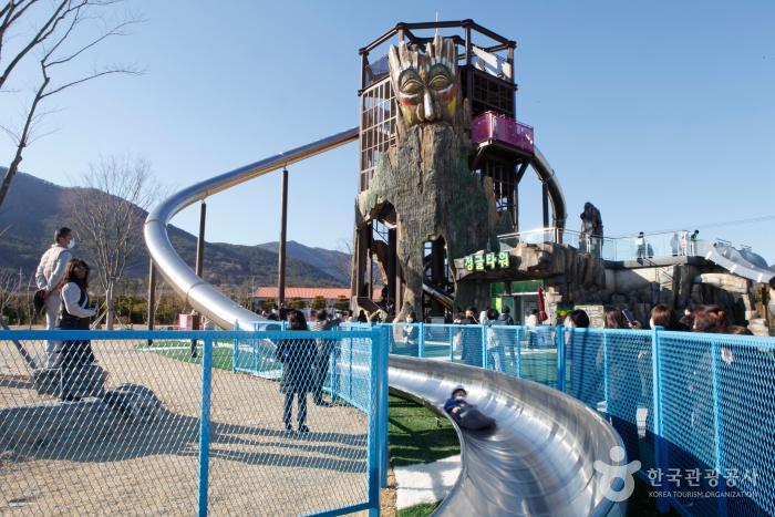 아이가 대형 미끄럼틀을 타고 내려오고 있다.