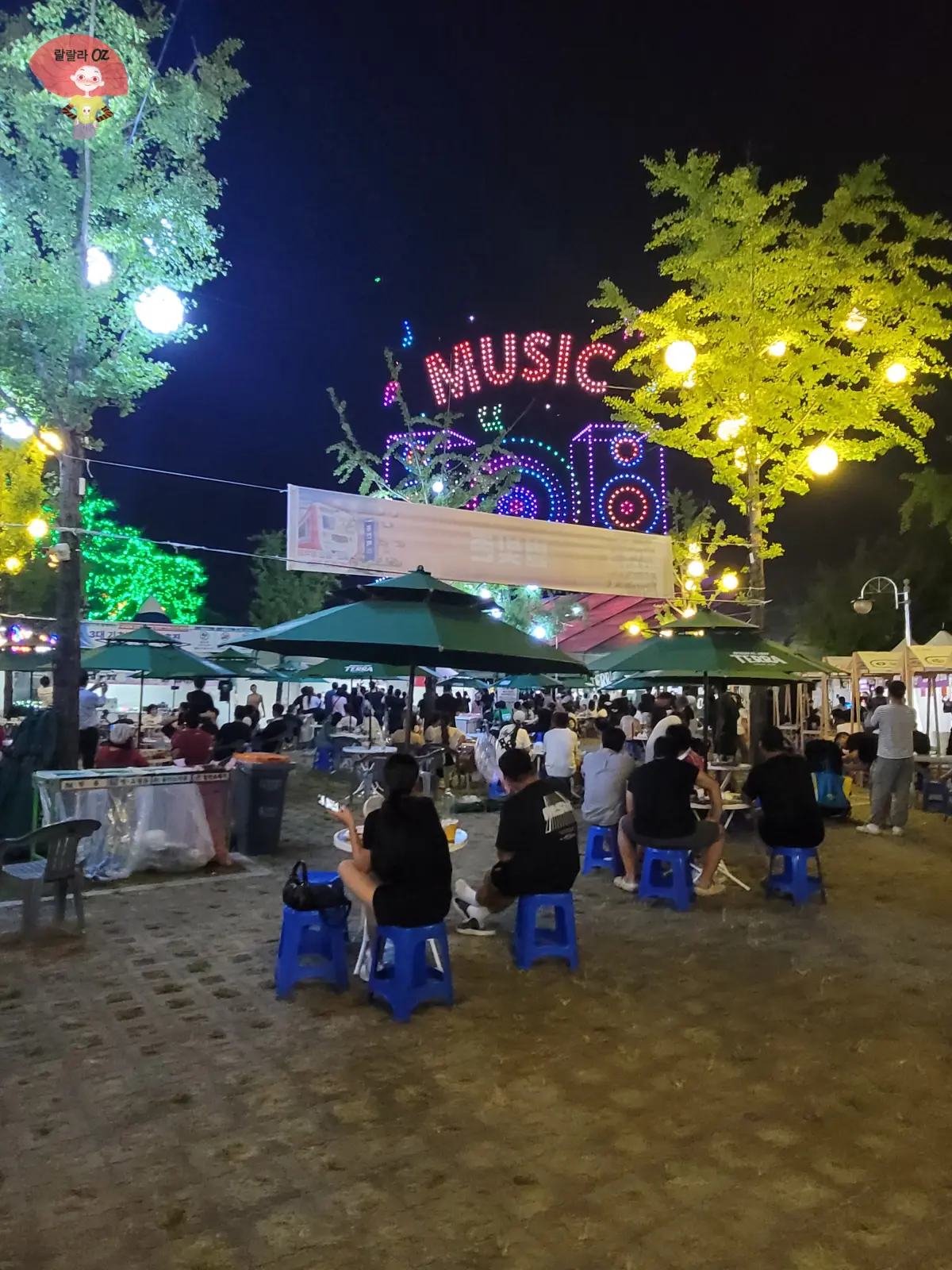 강원도-홍천-맥주축제-드론라이트쇼에서-밤하늘에-만든-music이라는-글자와-악기들-그리고-구경하는-사람들