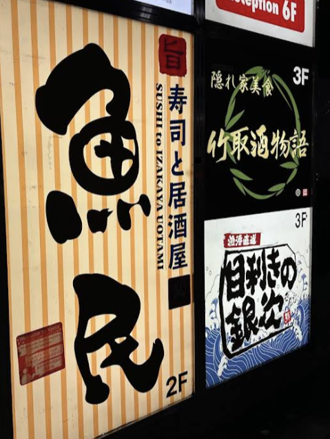 건물 내부에 다양한 음식점 간판이 보인다. 우오타미 간판도 보인다.