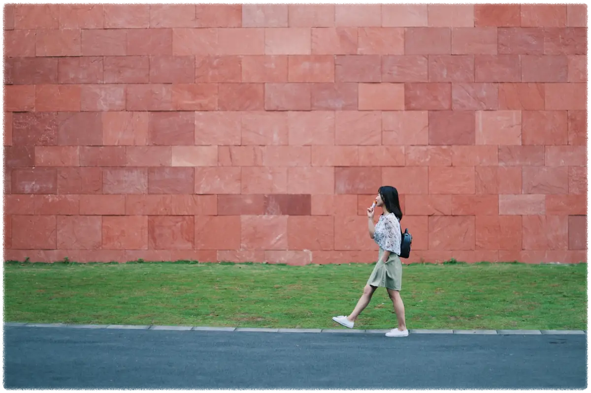 갈색무늬-벽돌길을-걸어가고-있는-여성