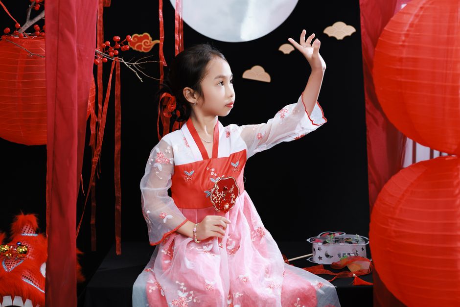 Young girl in Korean hanbok celebrating a traditional festival in a vibrant setting.