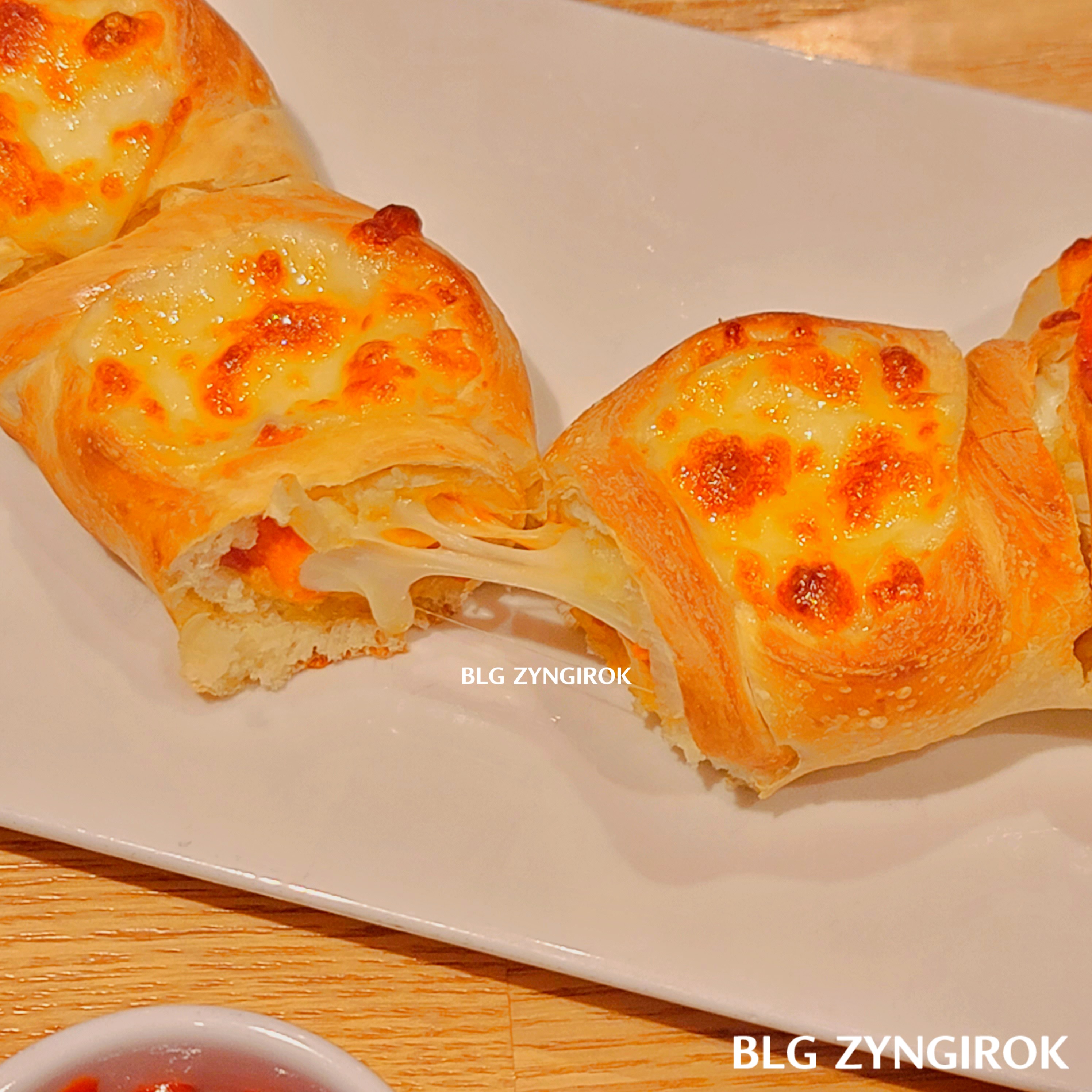 페퍼로니 프레즐을 반 가른 모습이다. 치즈가 늘어나 있는 모습이다.