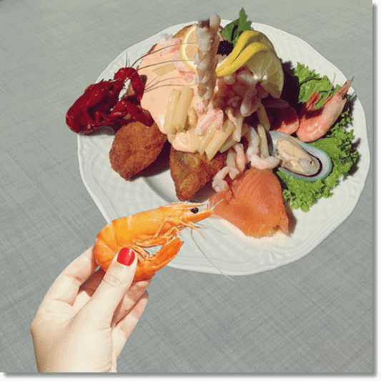 새우 요리와 찐 새우 들고 있는 여성