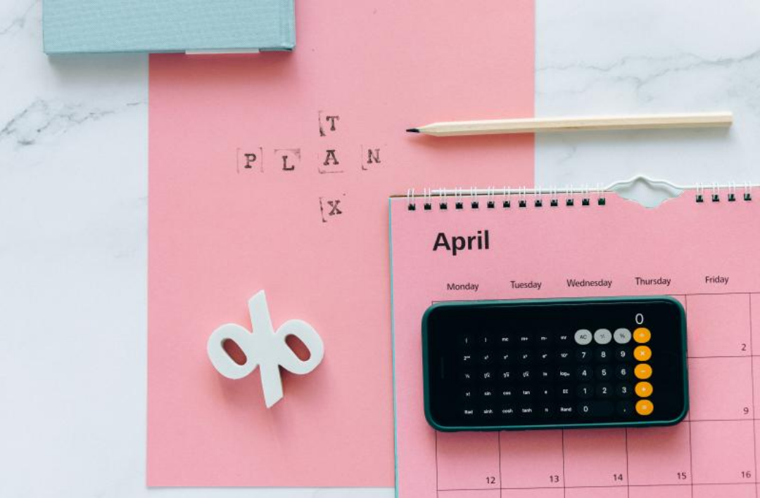 핑크색 달력과 계산기와 펜이 높여져있다.