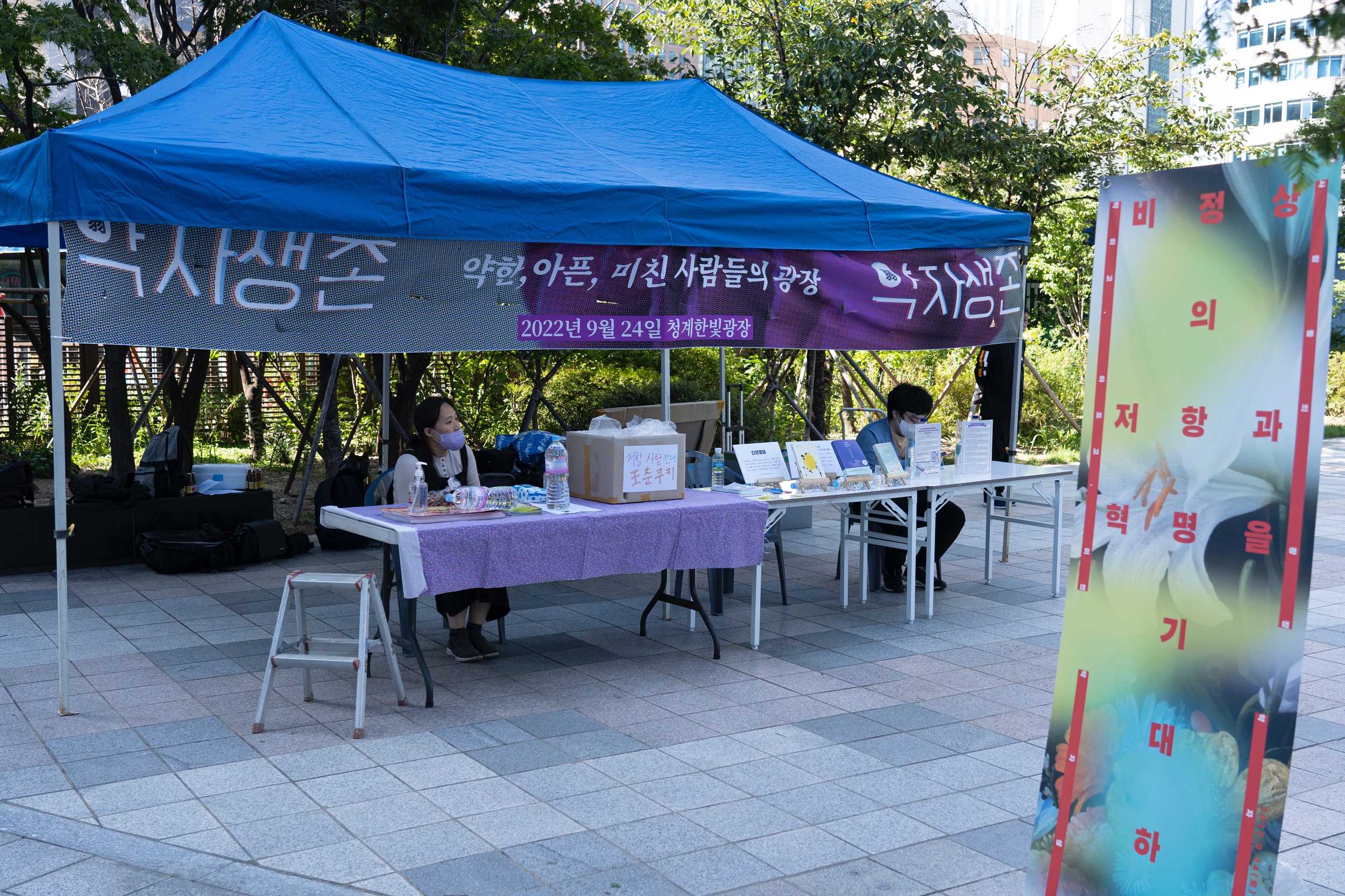 &lt;약자생존&gt; 인포부스에 Ecal 활동가와 다른몸들 목우 님이 앉아 있다.