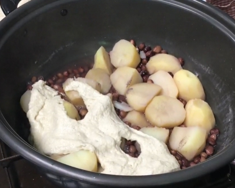 한국의 떡 종류 즘떡-익어가는 감자위에 반죽을 올린다.