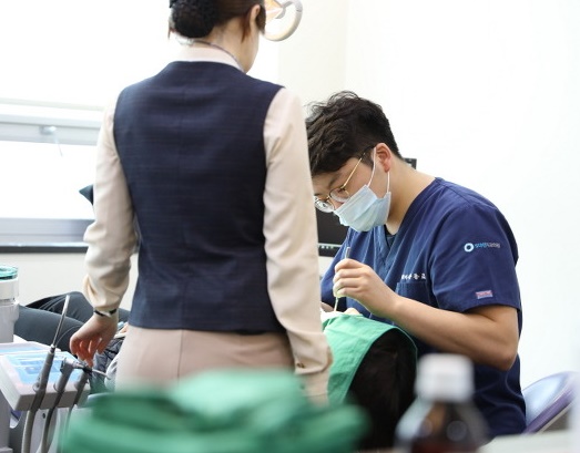 치과의사가 환자를 보는 중