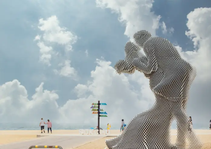 백사장 위 남여가 서로 껴안고 키스하는 조형물