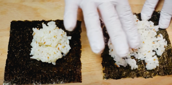 준비된 김 위에 양념한 밥을 고르게 펴고 있습니다