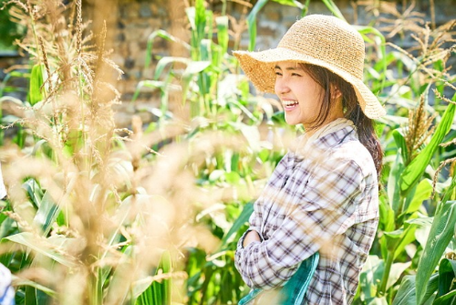 알트태그-리틀 포스스트 주인공 여배우가 들판에서 활짝 웃고 있습니다.