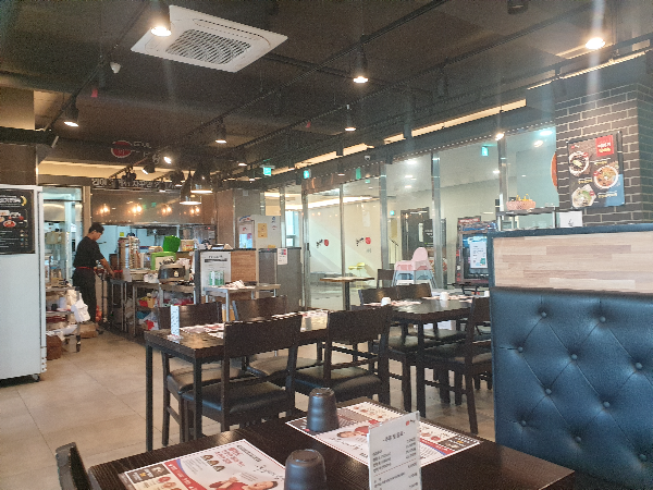 전체적으로 차분한 톤의 인테리어. 직원 한 명이 서서 일하고 있다.